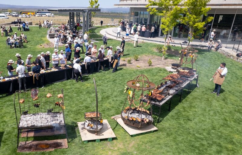 Evento ao ar livre com estações de fogo e churrasco nos jardins da Huentala Wines