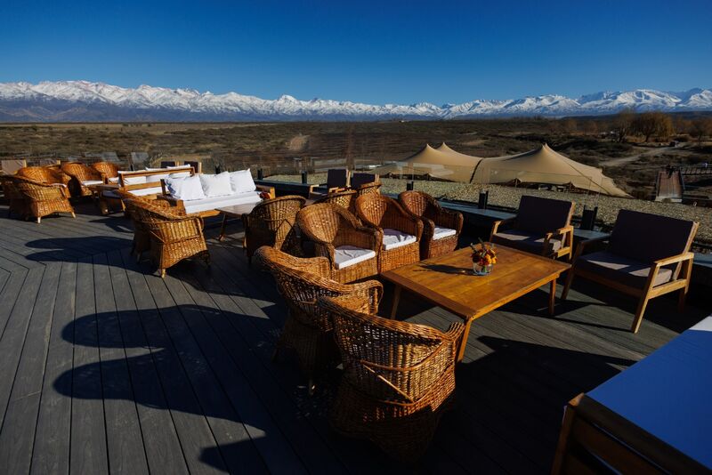 Lounge ao ar livre montado para evento no terraço da bodega, com os Andes ao fundo